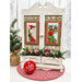 The completed projects staged on a decorative cabinet mount staged with greenery and a red MERRY ornament.