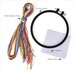 Contents of the kit, including a bundle of colorful embroidery floss next to a 6-inch hoop, Aida cloth, and a needle.