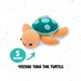 Crocheted turtle toy named Tina, measuring 5 inches with a soft orange body and teal spots.