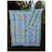 The Tumbles & Twirls quilts with pinwheel patterns, displayed outdoors beside the bonus mini quilt.