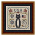 Finished and framed cross stitch project featuring a black cat, sawtooth stars, a flag, and florals.