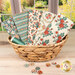 A stack of the Village Life - Petrol & Teal fat quarter bundle, with a basket and a window and a garden and buttons.