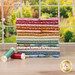 A stack of the fabrics included in the Village Life Blender fat quarter bundle, with a window and a garden and thread.