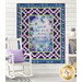 The completed Panel quilt staged on a white shiplap wall featuring inspirational quote hangs on a wall above a white rocking chair.