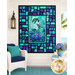 The completed Stained Glass Panel Quilt II, colored in bold cyan, blue, violet, and black fabrics from the Coral Reef collection by Northcott Fabrics, staged on a seaside porch with coordinating décor.