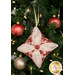 A closer look at the pink, cream, and red fabrics of the ornament, showing print colors and details.