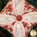 A super close up on the center of the ornament, showing fabric details as well as details on the center button.