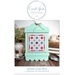 Front cover of the pattern featuring the finished piece, mounted in a mint green frame and staged with matching décor.