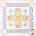 A head-on super close up on the patchwork of the quilt, demonstrating fabric colors and print details.