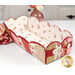 The completed Scalloped Basket, colored in green, white, pink, and red fabrics from the Elizabeth collection by Studio E, staged on a white table with coordinating flowers and décor.