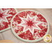 A close up on the center of the round hot pad, demonstrating the red and pink fabric details on the beautiful folded star center.