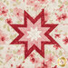 A super close up on the center of the hot pad, demonstrating the white, red, and pink fabric details on the beautiful folded star center.