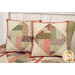 A shot of the two coordinating pillow projects, staged on a bed with the quilt.