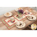 The Spinning Rail Fence table runner staged on a wooden dining table with plates, glasses, and a floral centerpiece.