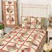 The Spinning Rail Fence staged on a white rustic bed with its coordinating pillows beside the draped table runner.