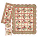 The completed Spinning Rail Fence quilt and coordinating table runner and pillows, isolated on a white background.