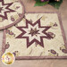 A close up on the square plum and cream Folded Star Hot Pads.