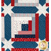 A close up on the patchwork of the quilt, demonstrating fabric colors, print details, and top quilting effects.