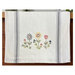A decorative kitchen towel featuring three floral blooms.