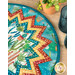 Close up on the table topper showing fabric details and colors on the folded points; coordinating décor peeks into frame from the upper right corner.