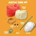 Contents of the kit featuring acrylic yarn balls, a crochet hook, safety eyes, a needle, and stuffing.