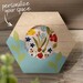 Painted hexagonal embroidery hoop frame with wood veneer finish.