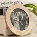 Decorated round embroidery hoop frame with wood veneer finish.