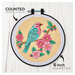 Counted cross stitch kit packaging featuring colorful a bird with cherry blossoms in a circular design. 