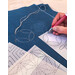 A shot of a model tracing sashiko designs onto her fabric with the stencil.