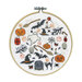 The completed cross stitch kit featuring halloween themed motifs, framed in a wooden embroidery hoop.