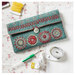 The completed Sewing Pouch closed on a table surrounded by sewing notions. 