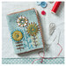 The completed Needle Case closed on a table surrounded by sewing notions. 
