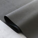 A shot of Charcoal Pebble Faux Leather, artfully draped over itself on a marble countertop.