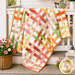 The completed Basket Case Quilt, colored in white, orange, yellow, green, and pink fabrics from the Peach Cobbler collection by Riley Blake Designs, artfully draped over a white porch railing and staged with coordinating décor.
