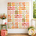 The completed Basket Case Quilt, colored in white, orange, yellow, green, and pink fabrics from the Peach Cobbler collection by Riley Blake Designs, hung on a white porch wall and staged with coordinating décor.