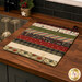 The completed Dry Ideas drying mat, colored in vintage christmas fabrics from the Christmas Tails collection by clothworks, staged on a wood kitchen counter with coordinating decor.