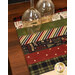 A close up on the mat demonstrating fabric prints and color details; two glasses sit in the upper left corner, showing scale.