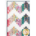 A close up on the upper left corner of the quilt, demonstrating details on the patchwork layout as well as the binding.
