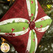 A super close up on the center of the ornament, showing fabric details as well as details on the center button.