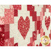 An angled close up on the patchwork chain and heart blocks, demonstrating fabric and top quilting details.