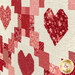 An angled close up on the patchwork chain and heart blocks, demonstrating fabric and top quilting details.