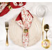 A top down shot of the napkin with the cream floral side out, showcasing the geometric print; the napkin is staged with a cream plate and matching table setting.
