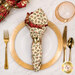 A top down shot of the napkin with the cream fabric facing out, staged on a coordinating gold table setting on a wood table.
