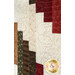 A close up on the patchwork of the quilt, demonstrating fabric colors and print details as well as top quilting effects.