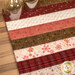 A close up on the mat demonstrating fabric prints and color details; two glasses sit in the upper left corner, showing scale.