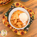 A top down shot of one of the cozies, demonstrating function by holding a bowl of apple pie and vanilla ice cream.