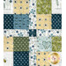 A close up on the patchwork of the quilt, demonstrating fabric color and print details.