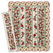 The completed Christmas Lane Quilt and table runner, colored in cream, green, red, pink, and blue fabrics from the Christmas Greetings collection by Riley Blake Designs, isolated on a white background. 