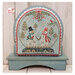 The Snow Globe Wooden Backer display frame painted and displaying the Mistletoe Kisses finished cross stitch project.