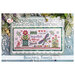 The finished cross stitch project featuring flowers, dragonflies, and sewing motifs mounted on a dusty blue and white wooden display frame.